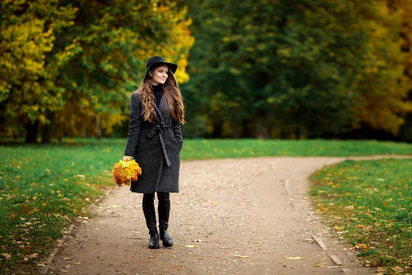 Donna con foglie autunnali in mano e acero giallo autunno giardino sfondo — Foto Stock