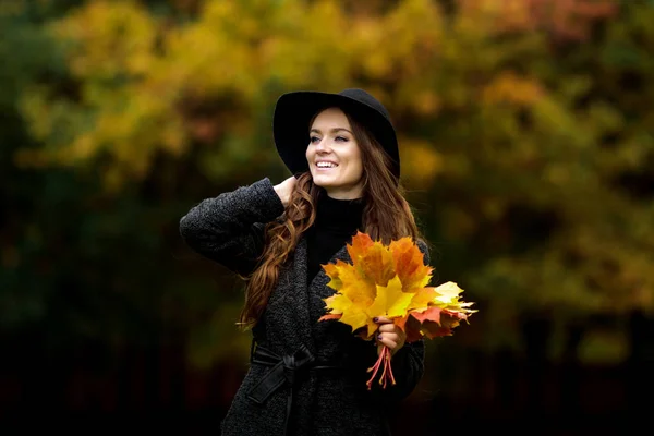 Žena s podzimní listí v ruce a pád zahradní pozadí žluté javor — Stock fotografie