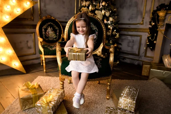 Pieni hymyilevä tyttö joululahjalaatikolla . — kuvapankkivalokuva