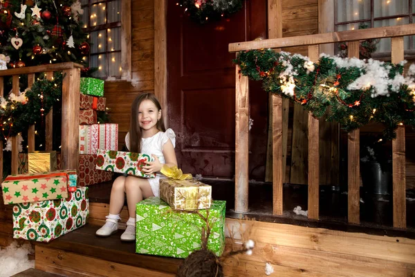 Маленькая улыбающаяся девочка с рождественской подарочной коробкой . — стоковое фото