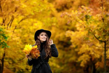 sonbahar kadınla el bırakır ve sarı akçaağaç Bahçe arka plan düşmek