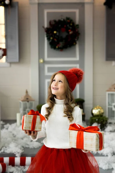 Glückliches kleines Mädchen, das viele Schachteln mit Geschenken in der Hand hält. Winterurlaub, Weihnachten und Menschen-Konzept. — Stockfoto