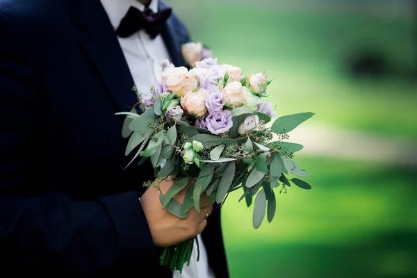 Wedding bouquet in the hands of the groom — Stock Photo, Image
