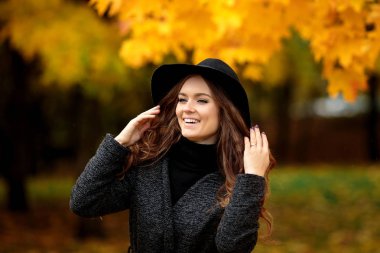 Mutlu genç kadın bir sonbahar Park şapkalı