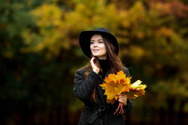 sonbahar kadınla el bırakır ve sarı akçaağaç Bahçe arka plan düşmek