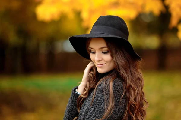 Boldog, fiatal nő, egy kalap, egy őszi parkban — Stock Fotó