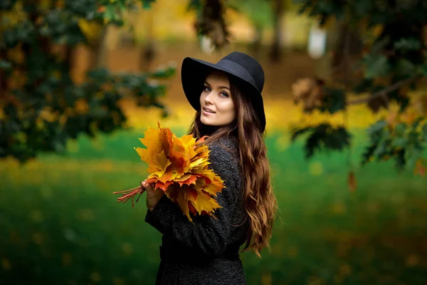 秋の女性手に葉し、黄色のもみじの庭の背景に落ちる — ストック写真