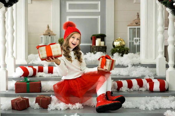 Glückliches kleines Mädchen, das viele Schachteln mit Geschenken in der Hand hält. Winterurlaub, Weihnachten und Menschen-Konzept. — Stockfoto