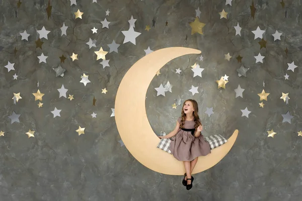 大きな月の上に座っての少女。夢の少女 — ストック写真