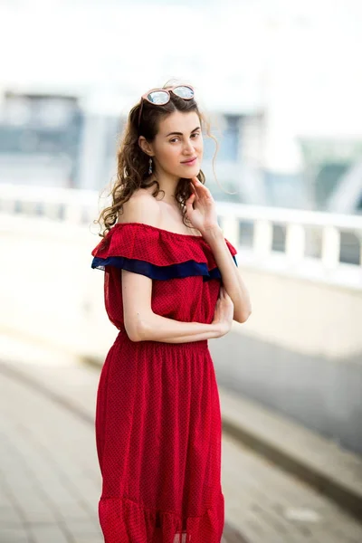 Een portret van een mooi meisje in glazen in een rode jurk — Stockfoto