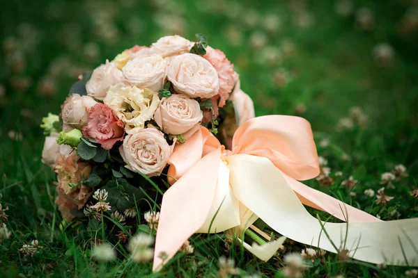 Ramo de boda de rosas rosadas y blancas tumbadas en la hierba — Foto de Stock