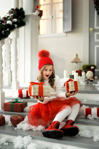 Glückliches kleines Mädchen, das viele Schachteln mit Geschenken in der Hand hält. Winterurlaub, Weihnachten und Menschen-Konzept. — Stockfoto