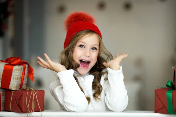Schönes kleines Mädchen feiert Weihnachten. Neujahrsferien. glückliches Mädchen im Weihnachtskostüm mit Geschenk — Stockfoto