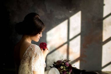 Gelin gibi karanlık studio iç kapalı sandalyede evde oturan beyaz elbiseli.