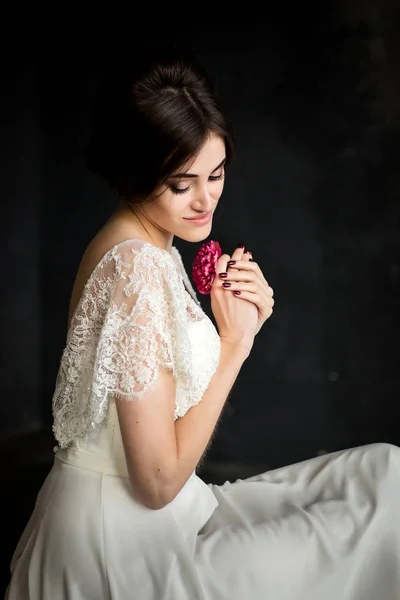 Young beautiful stylish woman, bride, spring trend, flowers, hairstyle, beauty make-up, white dress, dark background — Stock Photo, Image