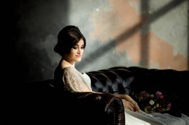 Gelin gibi karanlık studio iç kapalı sandalyede evde oturan beyaz elbiseli.