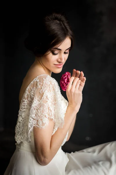 Jovem bela mulher elegante, noiva, tendência primavera, flores, penteado, maquiagem beleza, vestido branco, fundo escuro — Fotografia de Stock