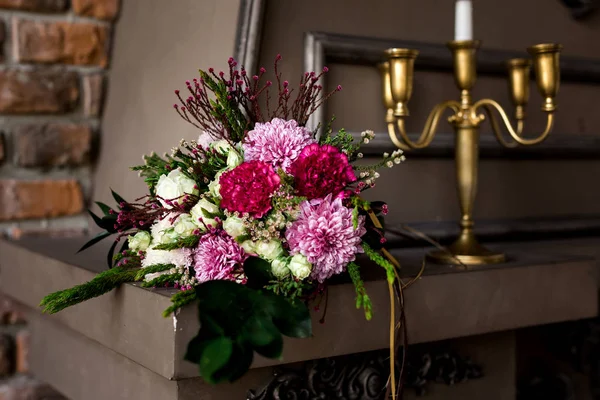 Lareira decorativa marrom com arranjo de flores e velas — Fotografia de Stock