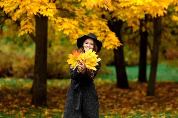 Γυναίκα με φθινόπωρο αφήνει στο χέρι και πτώση κήπων φόντο κίτρινο σφενδάμου — Φωτογραφία Αρχείου