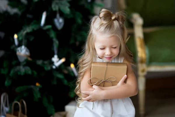 幸せな小さな笑顔とかわいい女の子クリスマス ギフト ボックス。メリー クリスマスとハッピー ホリデー. — ストック写真