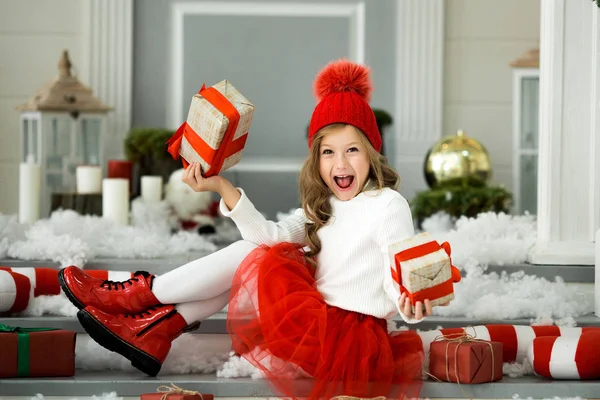 Lycklig liten flicka håller en massa lådor med gåvor. Vinter semester, jul och människor koncept. — Stockfoto