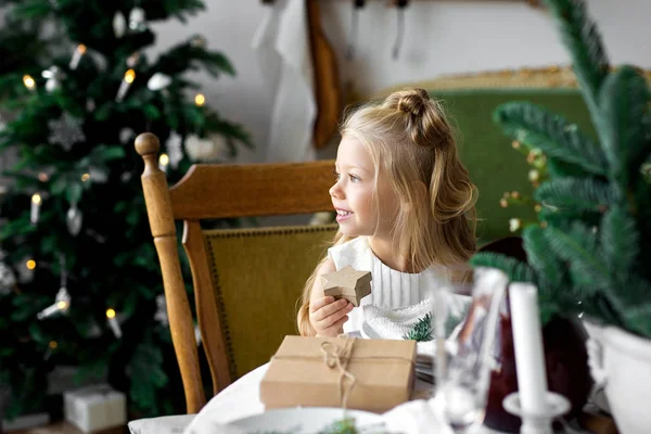 Feliz Navidad y Felices Fiestas. Alegre linda niña abriendo un regalo de Navidad . — Foto de Stock