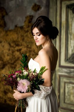 Gelin gibi karanlık studio iç kapalı sandalyede evde oturan beyaz elbiseli.