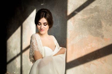 düğün portre ile yıpranmış beton duvar odadaki poz beyaz elbiseli güzel gelinin
