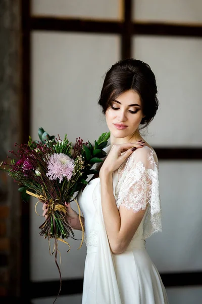 elegant bride with flower bouquet. Portrait of beautiful bride in white dress