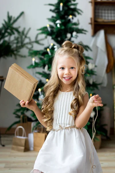 幸せな小さな笑顔とかわいい女の子クリスマス ギフト ボックス。メリー クリスマスとハッピー ホリデー. — ストック写真