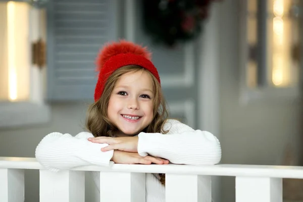 Красивая Маленькая Счастливая Девочка Празднует Рождество Опираясь Белый Забор — стоковое фото