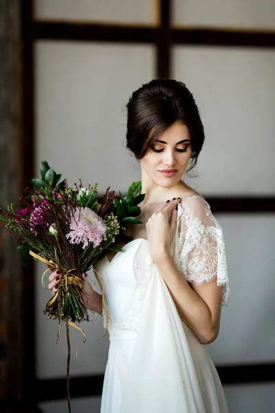 花の花束とエレガントな花嫁 白いドレスの美しい花嫁の肖像画 — ストック写真
