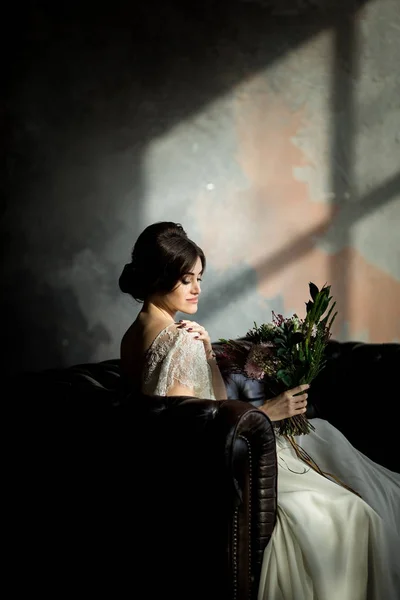 elegant bride with flower bouquet in hands. Portrait of beautiful bride in white dress