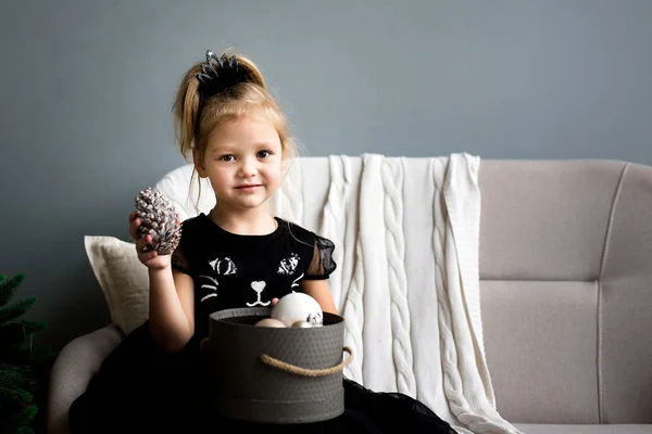 Маленькая Девочка Сидит Диване Держа Коробку Рождественскими Игрушками — стоковое фото