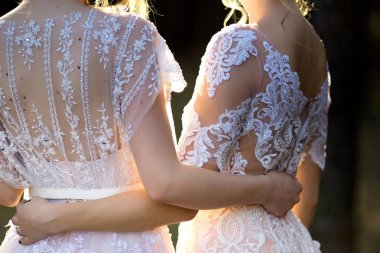 İki güzel gelin birlikte ormanın içinde poz 