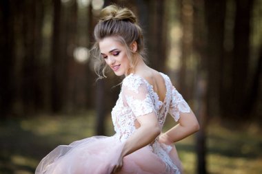 Beyaz elbiseli güzel gelin. Gelin ormanda yürüyor