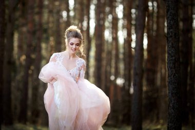 Beyaz elbiseli güzel gelin. Gelin ormanda yürüyor