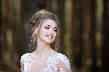 Beyaz elbiseli güzel gelin. Gelin ormanda yürüyor