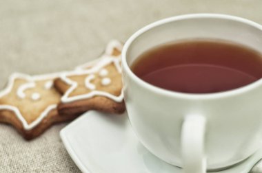 Beyaz seramik bardak sıcak çay ve festival ev yapımı zencefilli kurabiye, yakın çekim