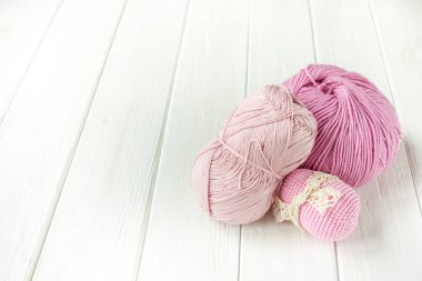 İplik örgü pembe bir beyaz tahta bac topları içine haddelenmiş