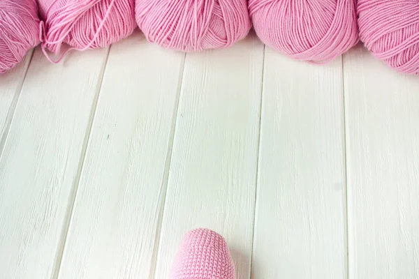 Fils à tricoter roulés en boules sur un fond de bois blanc . — Photo