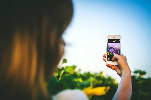 Jeune femme prendre des photos dans le champ de tournesol — Photo