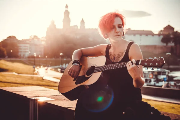 Chica tocando la guitarra en el fondo de la ciudad vieja Cracovia —  Fotos de Stock