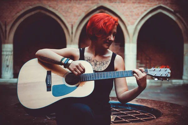 Девушка играет на гитаре на старых улицах Кракова, Польша — стоковое фото