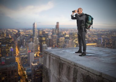 Businessman watching from above the city clipart