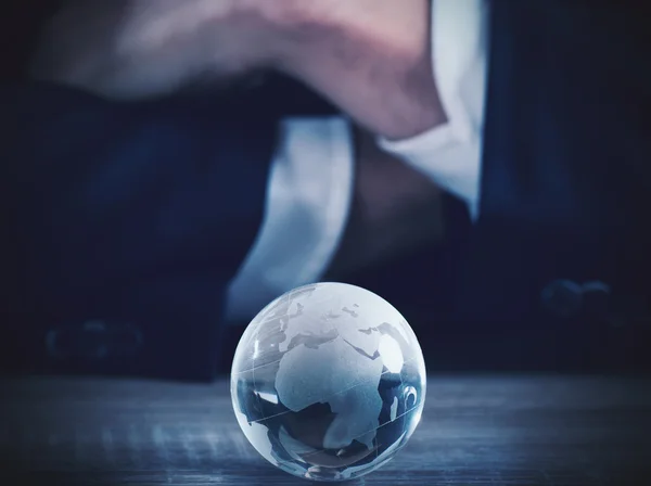 Zakenman met wereld glazen bol — Stockfoto