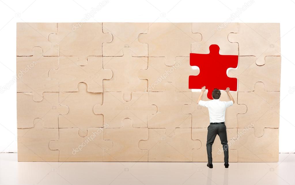 Businessman  inserting a missing red piece