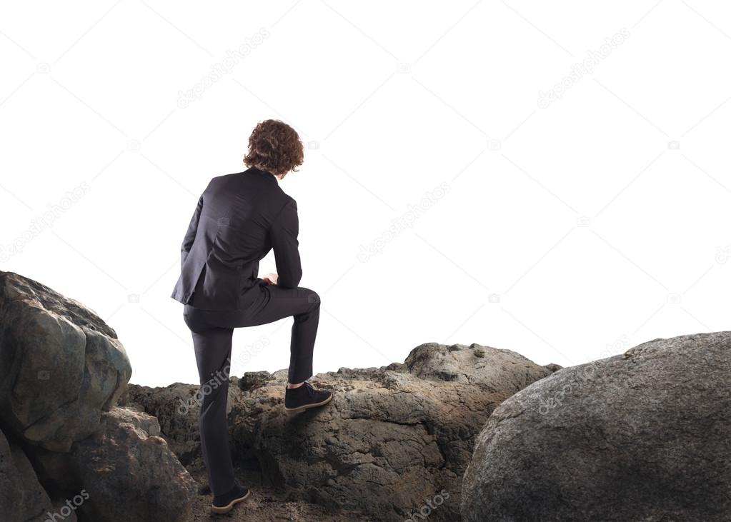 Businessman leaning on a rock