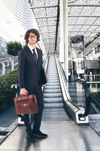 Empresário na frente de uma escada rolante — Fotografia de Stock