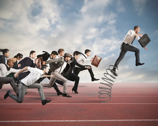 Businessman jumping on a spring — Stock Photo, Image